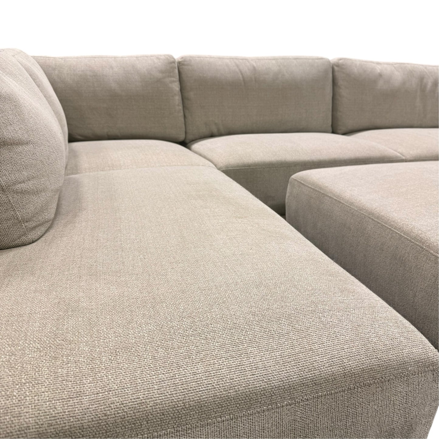 Couch Quest modular sectional sofa in light beige fabric with matching ottoman and plush cushions